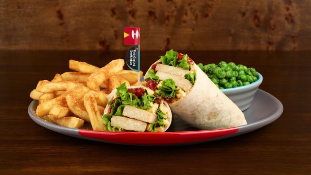 The Great Imitator Wrap on a plate with optional sides Macho Peas and Creamy Mash