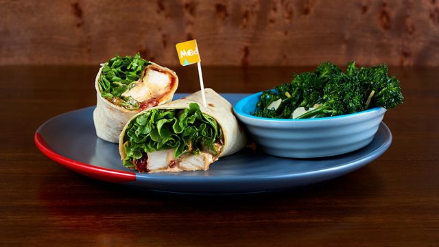 Grilled Chicken Wrap on a plate with an optional side of Long Stem Broccoli