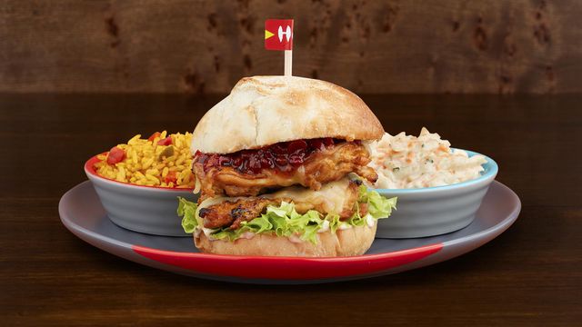 Sunset Burger on a plate with optional sides Spicy Rice and Mixed Leaf Salad