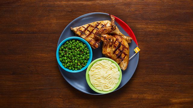 1/2 Chicken on a plate with optional sides Macho Peas and Creamy Mash